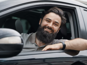 Young man smiling while driving a car