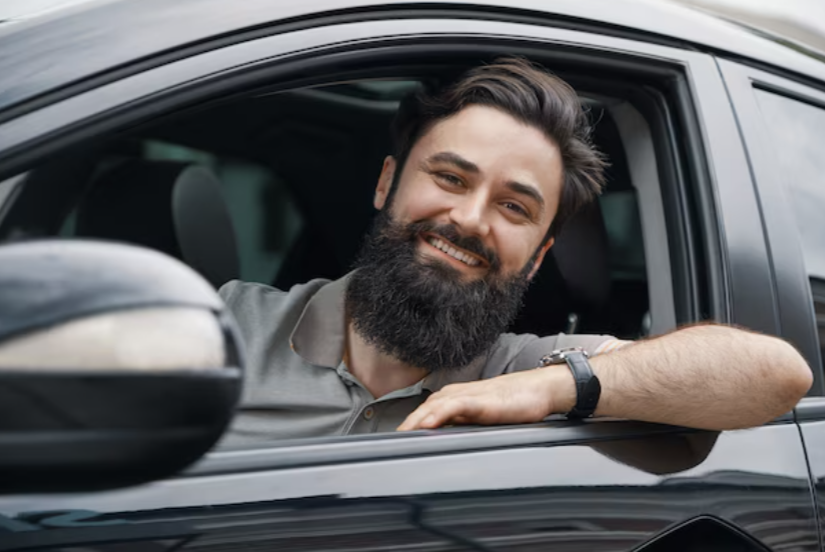 Young man smiling while driving a car